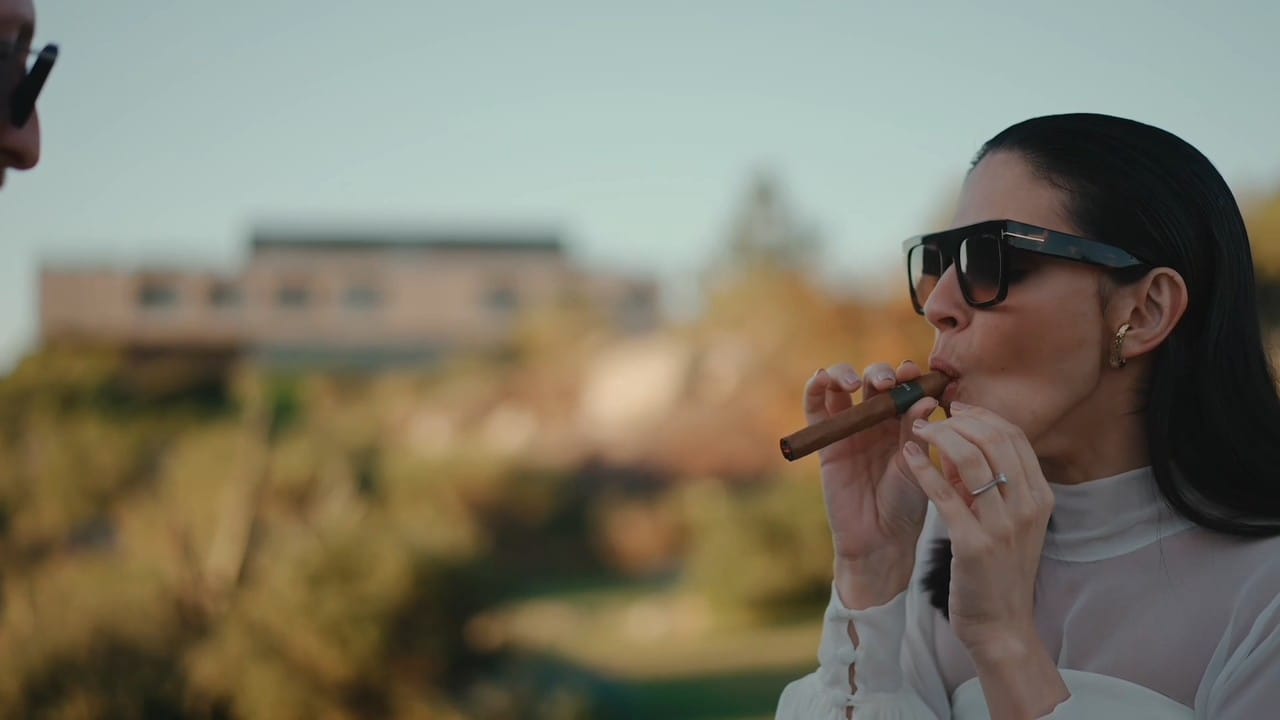 Juliana encendiendo un habano al atardecer, Fasano Las Piedras